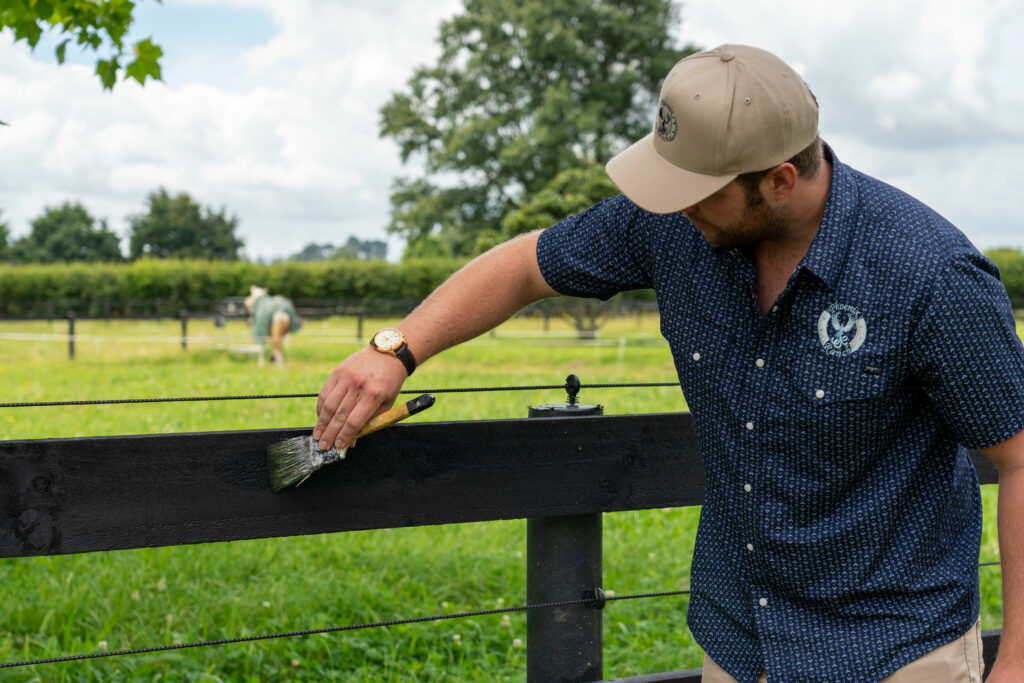 Man painting timber fence