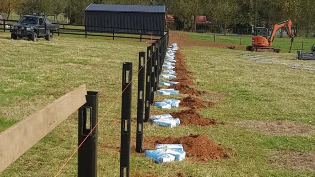 Installation of steel post and rail fence